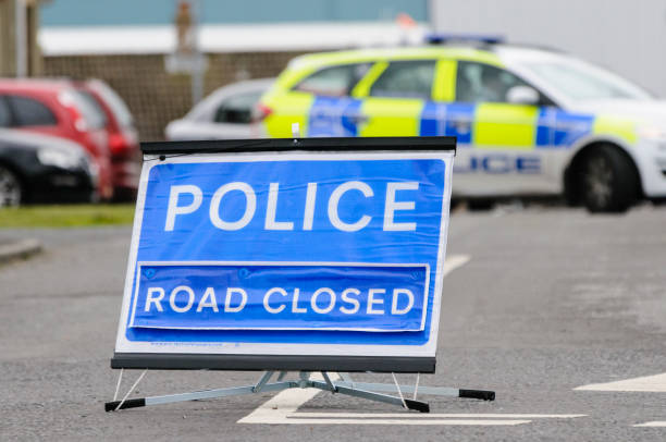 Police road closed sign with police car blocking the road Police road closed sign with police car blocking the road northern ireland photos stock pictures, royalty-free photos & images