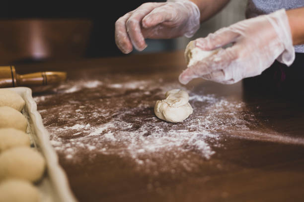 mãos de uma mulher fazendo massa com luvas de plástico na mesa na turquia - bread kneading making human hand - fotografias e filmes do acervo