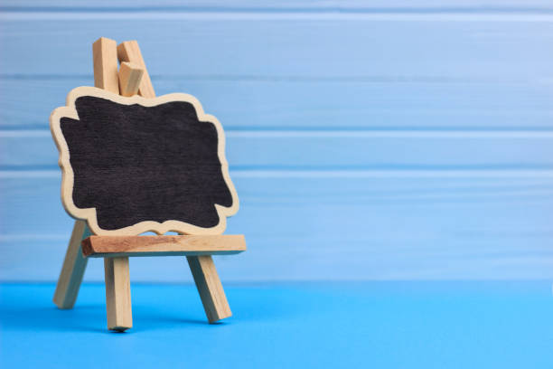 istock decorative easel on a blue, wooden background, place for text or advertising 1219780507