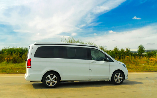 Minivans Car in road. Mini vans Auto vehicles on driveway. European transport for logistics services utilities at transportation work on motorway or highway.