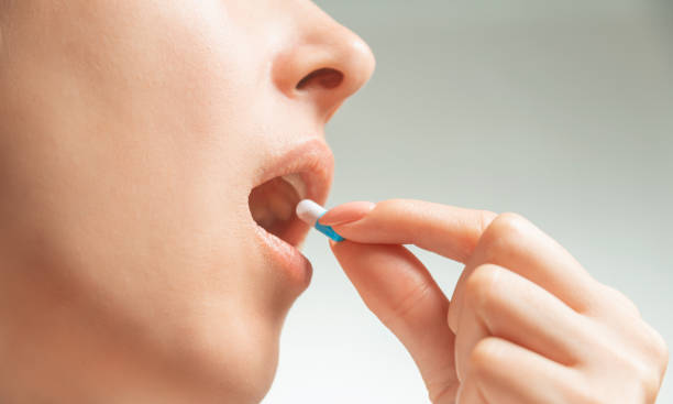 istock Woman taking a medical capsule or vitamin. 1219786408