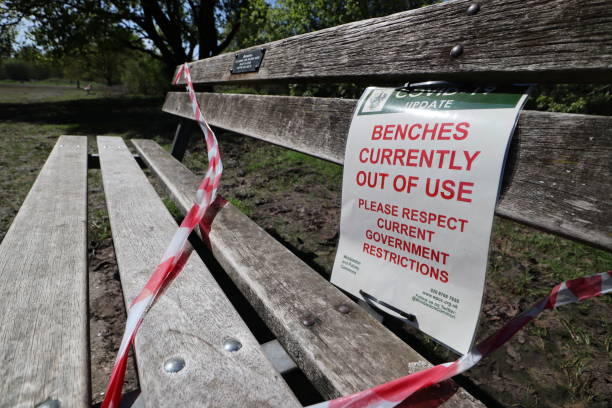 Wimbledon Common, London, 19th April 2020. Signs warning about park benches out of use due to COVID-19. Wimbledon Common, London, 19th April 2020. Signs warning about park benches out of use due to COVID-19, close up wimbledon seats stock pictures, royalty-free photos & images