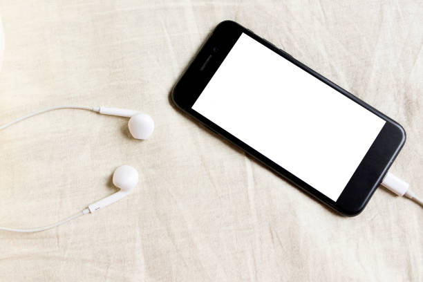 istock Smartphone with headphones top view in rumpled bed close-up 1219786855