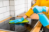 Person cleaning the stove in kitchen