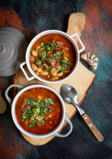 istock Bean soup with meat and vegetables served on a rustic board with garlic. Traditional Balkan soup or stew Corbast Pasulj (Grah). Top view, copy space 1219787168