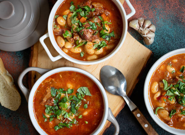 istock Bean soup with meat and vegetables served on a rustic board with garlic. Traditional Balkan soup or stew Corbast Pasulj (Grah). Top view, copy space 1219787250