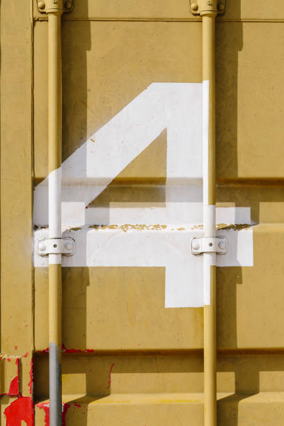 istock White silk-screen printing of number 4 on a mustard-colored shipping container 1219787328