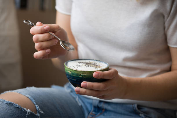 Closeup of woman's hands holding cup with organic yogurt with blueberries, coconut and fresh mint.. Homemade vanilla yogurt in girl's hands. Breakfast, snack. Healthy eating and lifestyle concept Closeup of woman's hands holding cup with organic yogurt with blueberries, coconut and fresh mint. Homemade vanilla yogurt in girl's hands. Breakfast, snack. Healthy eating and lifestyle concept eating chia seeds stock pictures, royalty-free photos & images