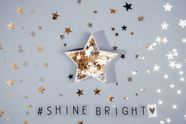 Top view hashtag Shine bright phrase and star shape full of glittering stars confetti on the grey background with shining stars. Everyday Inspirational quotes concept. Be unique. Selective focus. Top view hashtag Shine bright phrase and star shape full of glittering stars confetti on the grey background with shining stars. Everyday Inspirational quotes concept. Be unique. Selective focus opportunity dictionary definition stock pictures, royalty-free photos & images