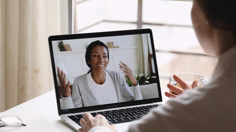 Female psychologist consulting african woman client during online counseling session