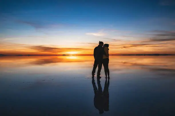 Photo of Young Couple Kissing at Sunrise, Uyuni Salt Flats, Bolivia