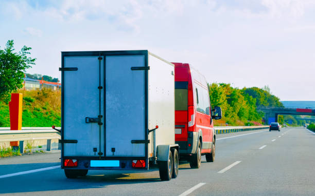 istock Mini van carrying trailer at asphalt road in Slovenia 1219791841