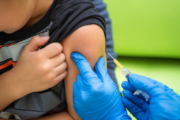 Pediatrician makes vaccination to a small boy.