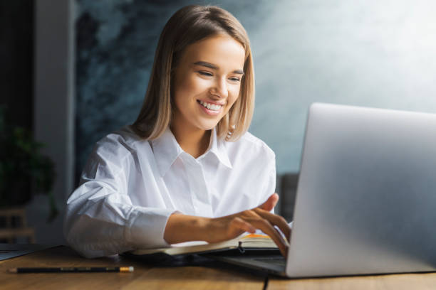 istock Young female working on successful project. Motivated specialist executing tasks efficiently in office. Girl typing 1219794774