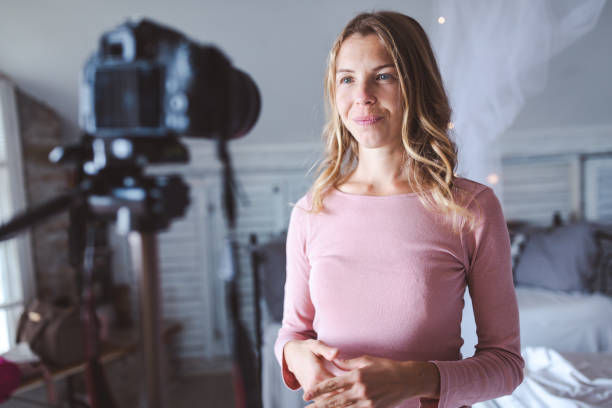 istock Happy female vlogger live streaming from living room 1219795183