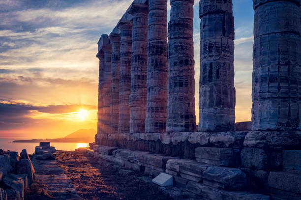Greece Cape Sounio. Ruins of an ancient temple of Poseidon, Greek god of the sea, on sunset. Shot of temple ruins on sunset. Tourist landmark of Attica, Sounion, Greece