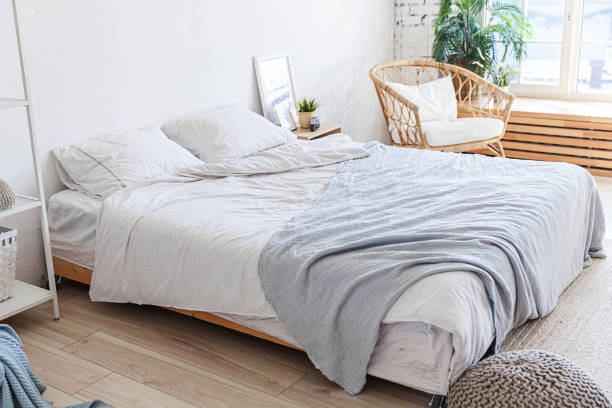 istock Stylish loft bedroom interior. Spacious design apartment with light walls large windows big bed. Clean modern decoration with elegant furniture in minimalist Scandinavian style 1219802081