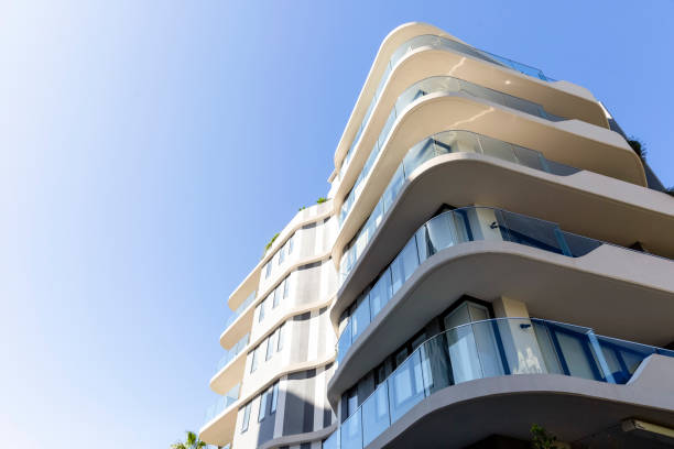 modernes mehrfamilienhaus, flachwinkelansicht, blauer himmelshintergrund mit kopierraum - sunny apartment window sky stock-fotos und bilder