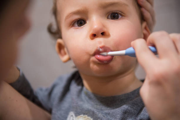 istock Toddler learning how to brush his teeth with a help from his mother 1219804250