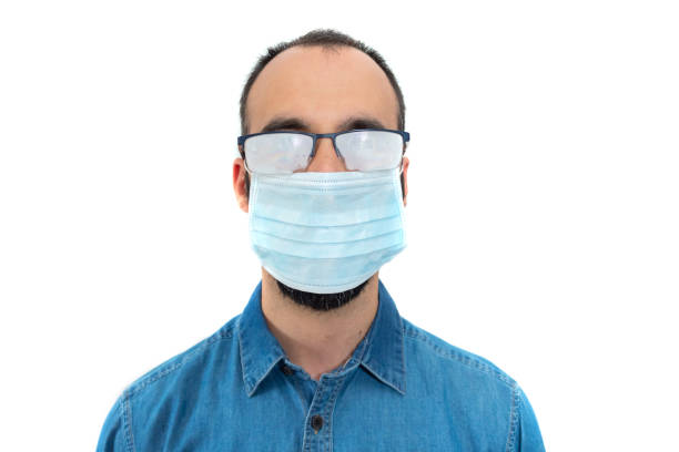 istock Man in denim shirt, face mask and misted glasses on white background 1219806049