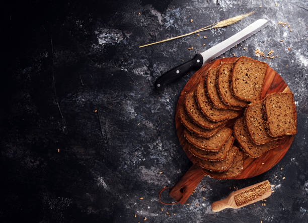 istock Sliced rye bread on cutting board. Whole grain rye bread with seeds on table 1219808238