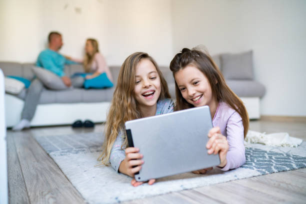 istock Little girls using digital tablet on the floor 1219808552