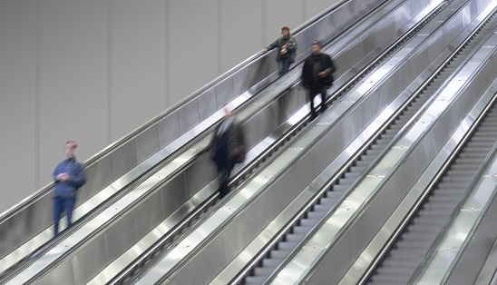 Social distancing with people keeping distance in escalator