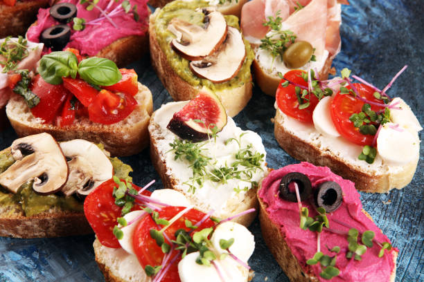 istock Assorted bruschetta with various toppings. Appetizing bruschetta or crudo crostini. Variety of small sandwiches. Mix bruschetta with tomatoes and basil 1219811088
