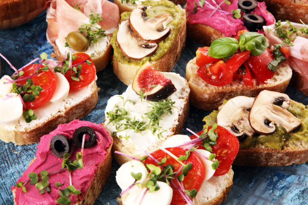 istock Assorted bruschetta with various toppings. Appetizing bruschetta or crudo crostini. Variety of small sandwiches. Mix bruschetta with tomatoes and basil 1219811097
