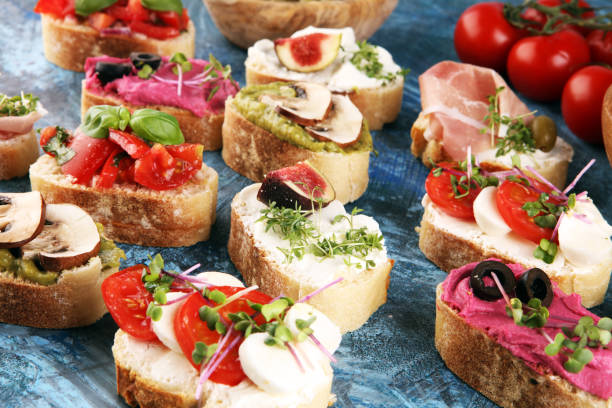 istock Assorted bruschetta with various toppings. Appetizing bruschetta or crudo crostini. Variety of small sandwiches. Mix bruschetta with tomatoes and basil 1219811105