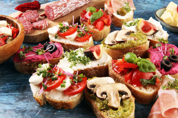 istock Assorted bruschetta with various toppings. Appetizing bruschetta or crudo crostini. Variety of small sandwiches. Mix bruschetta with tomatoes and basil 1219811862