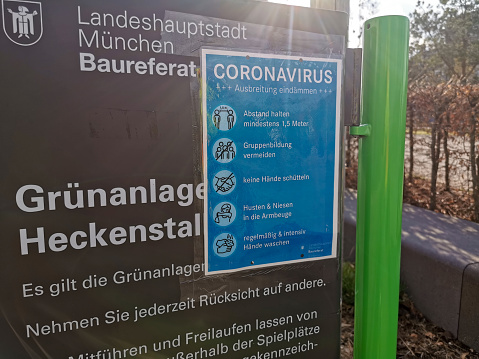 Munich, Germany - March 30, 2020: Coronavirus Info sign on a public park in Munich