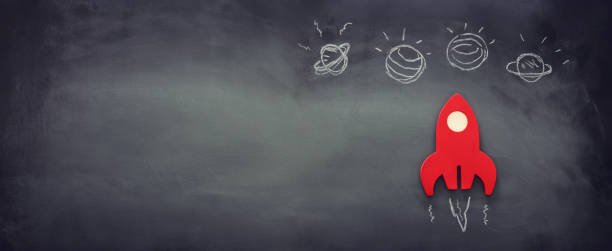 istock education or innovation concept. Wooden rocket over blackboard background. top view 1219812934