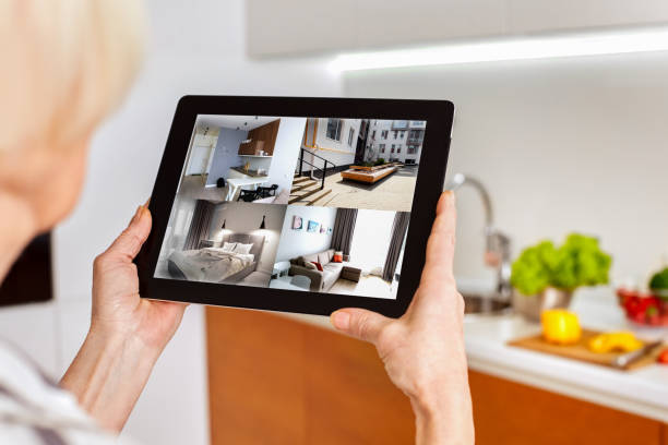istock Grey hair woman using modern tablet computer with smart house app 1219815103