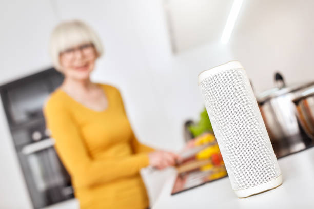 istock Senior woman standing in kitchen, cooking with smart speaker 1219815104