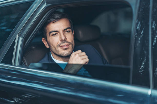 istock Businessman looking through a car's window 1219815494