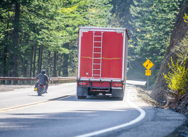 motocyklista wyprzedzania duży rig półciężarówka z czerwoną naczepą luzem na krętej górskiej drodze w zakazanej strefie zakazu wyprzedzania bez bezpiecznego widoku drogi - overtake zdjęcia i obrazy z banku zdjęć
