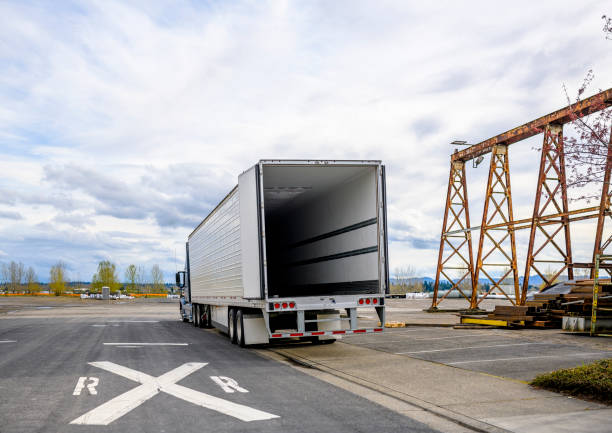 großer rig semi truck mit leerem kühlschrank sattelanhänger mit offener tür steht auf der straße schulter im industriellen lagerbereich wartet auf die nächste ladung für die lieferung - rules of the road stock-fotos und bilder