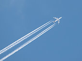 Plane with vapour trail on a sunny spring afternoon
