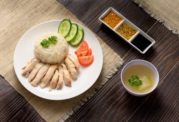 istock Hainanese chicken rice with soup and three sauces on dark wood table texture 1219833145