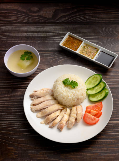 istock Hainanese chicken rice with soup and three sauces on dark wood table texture 1219833146