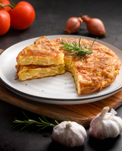 Spanish omelette with potatoes and onion and ingredient Spanish cuisine. Tortilla espanola. Rustic dark background close-up Spanish omelette with potatoes and onion and ingredient Spanish cuisine. Tortilla espanola. Rustic dark background omelet rustic food food and drink stock pictures, royalty-free photos & images