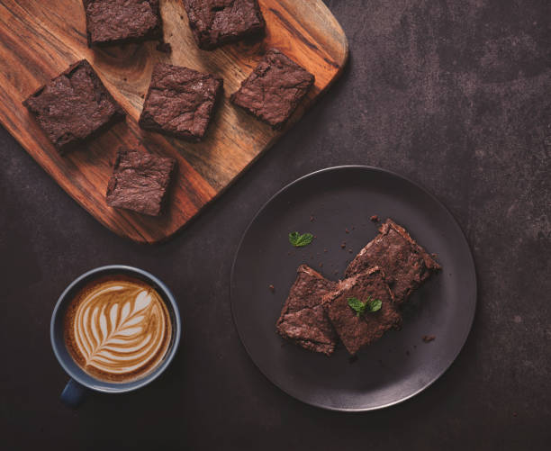 Brownies with Latte art on dark table and wooden cutting board