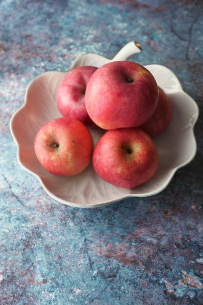high angle view of apples in a bowl on white background