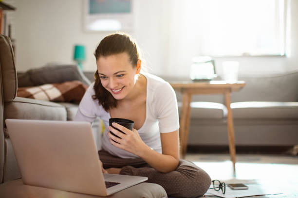 istock Young woman using a laptop at home 1219834776