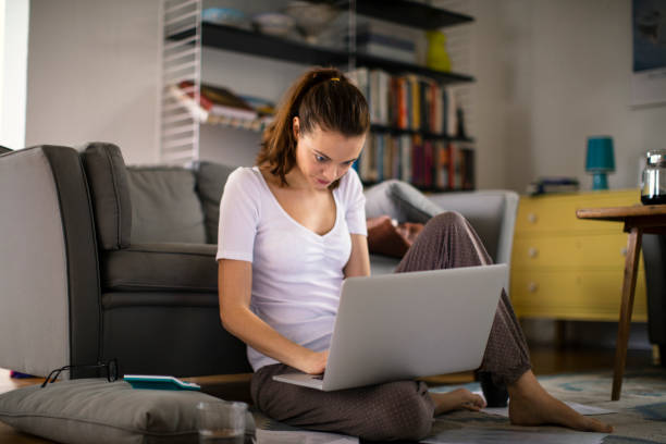 istock Young woman using a laptop at home 1219835516