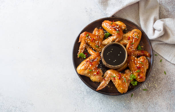 Fried chicken wings with soy sauce, sesame and hot pepper stock photo