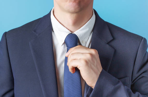 In this studio cutout, a clean cut young man wears a yellow shirt and striped neck tie as he looks at the camera with an expression of surprise and excitement.