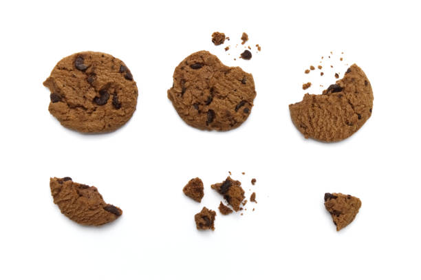 istock Chocolate chip cookies with some broken and crumbs isolated on white background. 1219844071