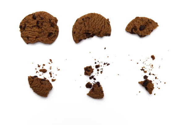 istock Chocolate chip cookies with some broken and crumbs isolated on white background. 1219844079
